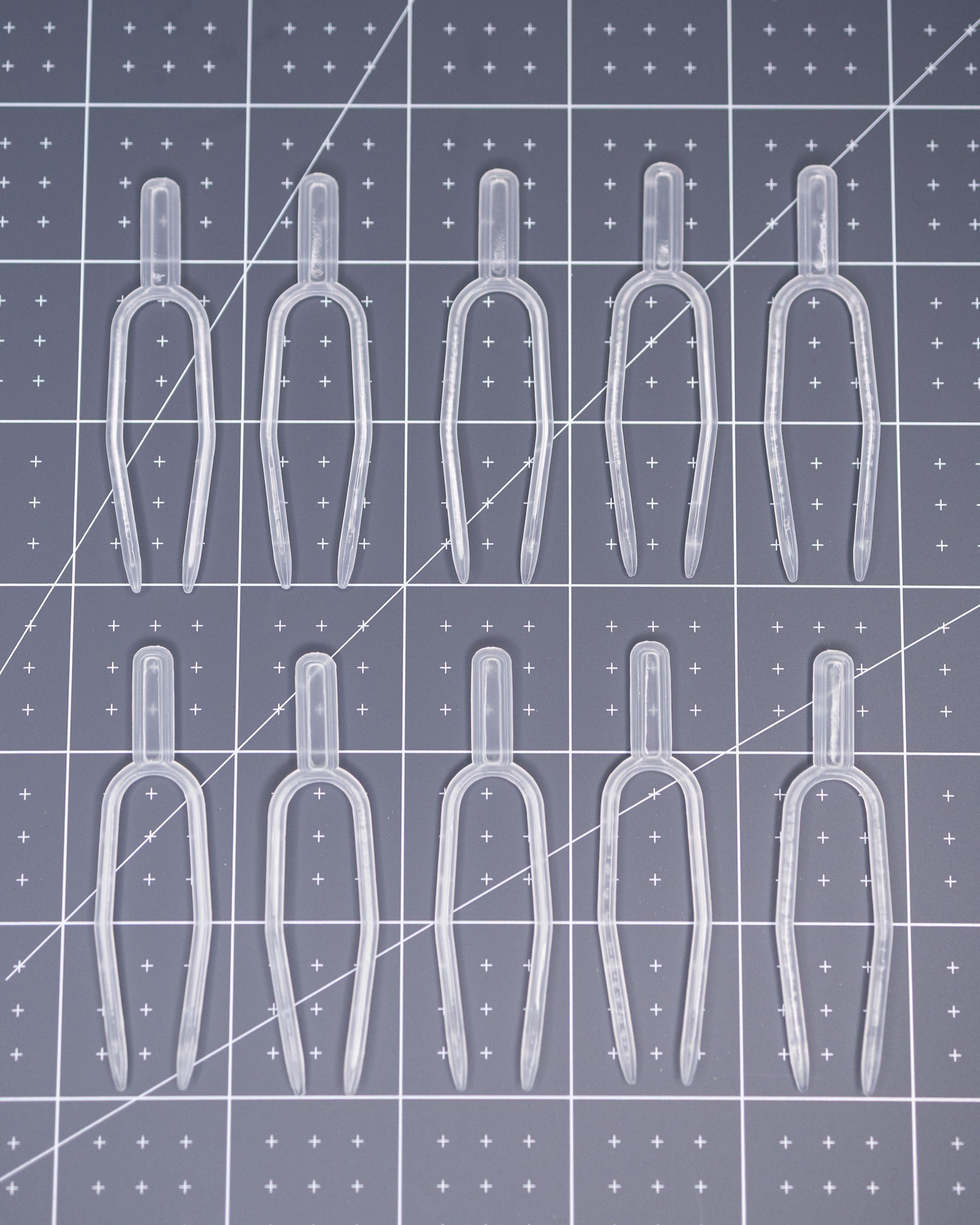 Clear plastic pins arranged on a grid-patterned surface