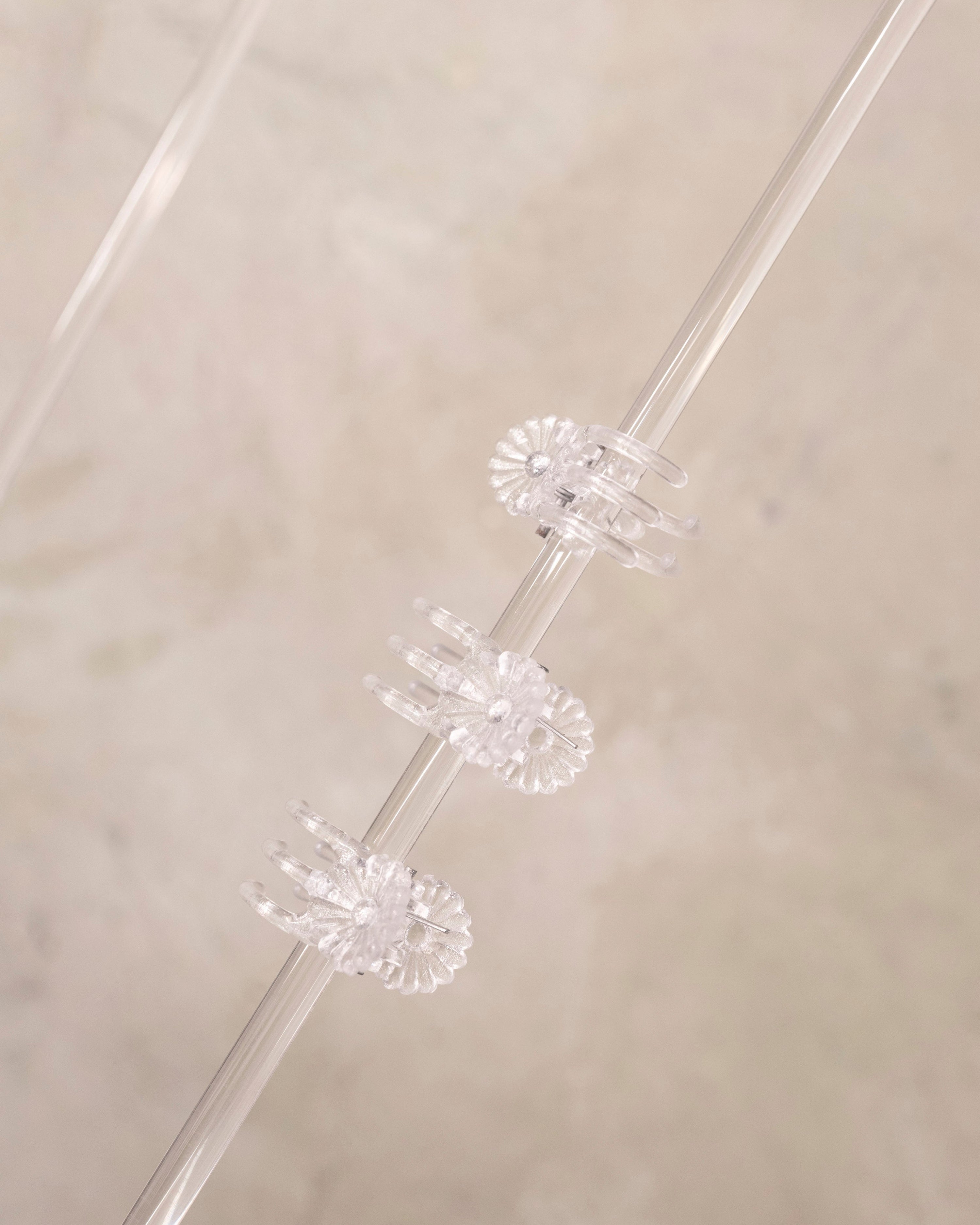 Clear plastic straws with decorative ends on a beige background