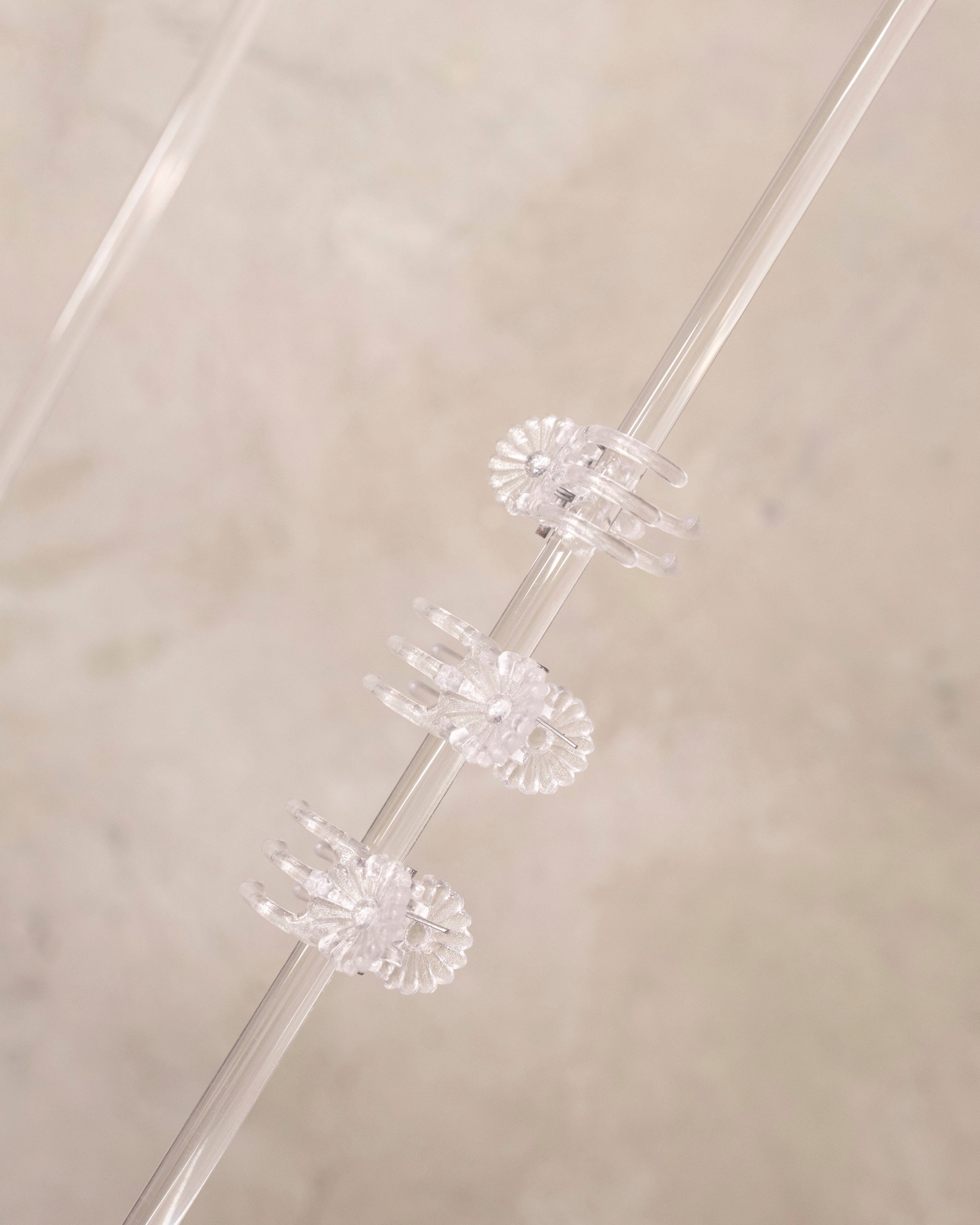 Clear plastic straws with decorative ends on a beige background