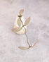 Small white vase with a branch on a textured gray background