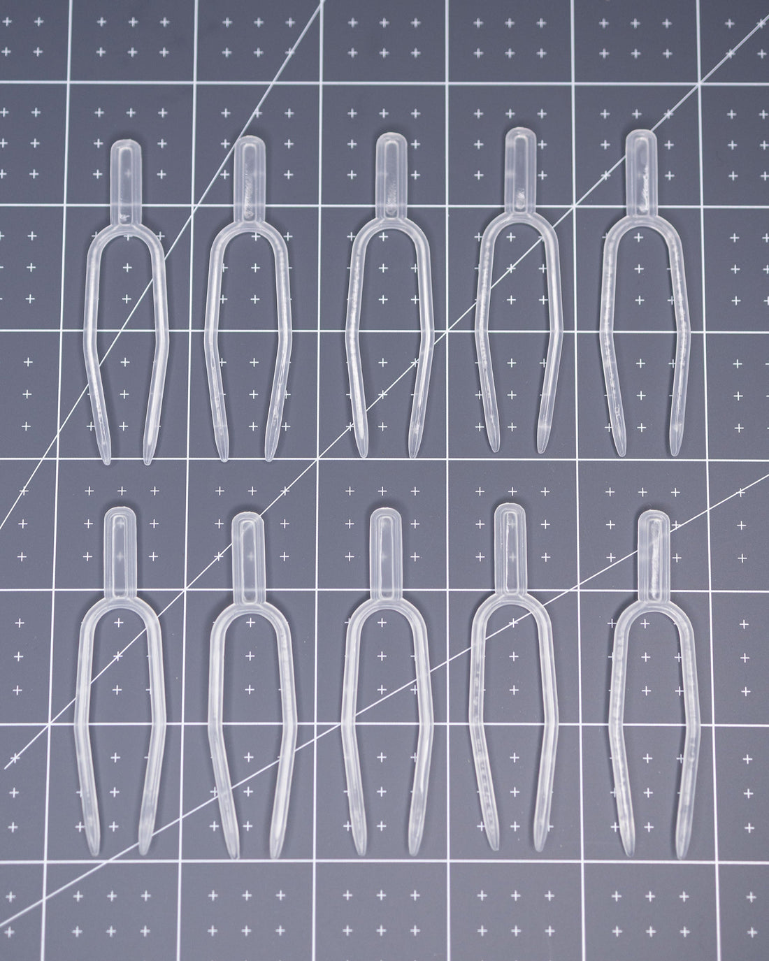 Clear plastic pins arranged on a grid-patterned surface