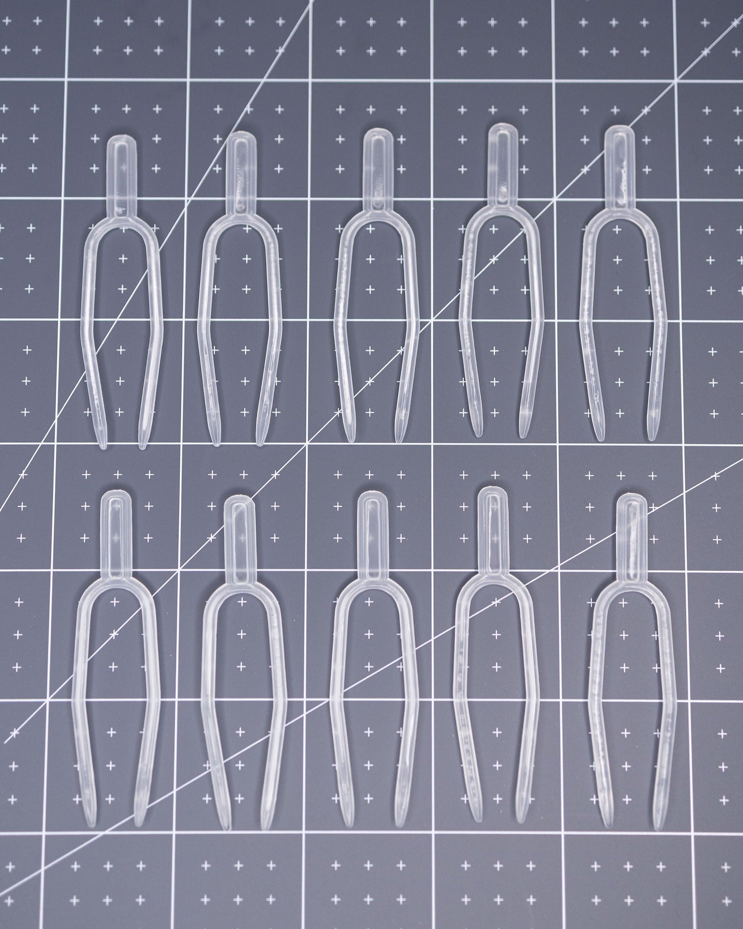 Clear plastic pins arranged on a grid-patterned surface